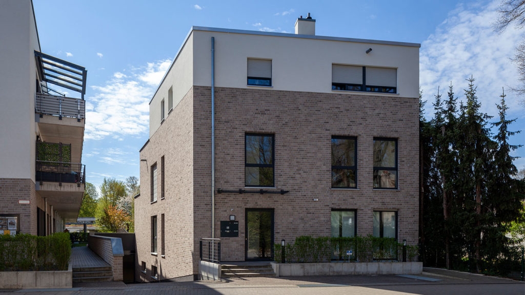 SKANDELLA-residential-office-complex-leverkusen-high-end-plaster-stone-side-view-building-entrance